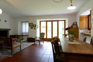 a kitchen and living room with a table and chairs at Bed and Breakfast da Käthy Agriturismo in Grono