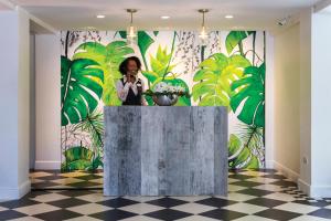 a woman taking a picture in front of a mural at Coco Palm in Gros Islet +109 photos