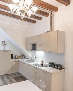 une cuisine avec des armoires blanches et un lustre dans l'établissement Doge's House, à Venise