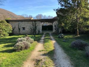 a stone house with a dirt road in front of it at Gîte la Mirmandelle in Mirmande