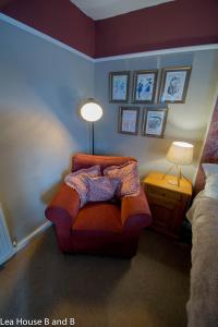 a living room with a chair and a lamp at Lea House Bed and Breakfast in Ross on Wye