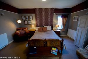 a bedroom with a bed and a couch in a room at Lea House Bed and Breakfast in Ross on Wye