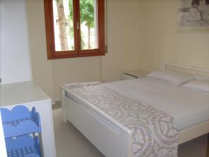 - une petite chambre avec un lit et une fenêtre dans l'établissement Condominio Rio Chico, à Lignano Sabbiadoro