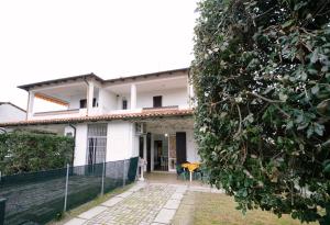 a white house with a fence in front of it at Villetta LINDA 10 in Lido delle Nazioni