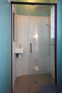 a shower with a sink and a glass shower door at " Le Léana Cardi " Fécamp Bord de mer in Fécamp