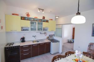 uma cozinha com um lavatório e um fogão forno superior em F-Holiday Apartment em Zadar