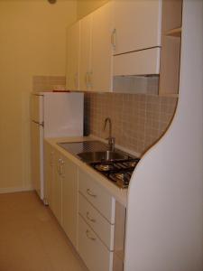 a small kitchen with a sink and a refrigerator at Condominio Rio Chico in Lignano Sabbiadoro