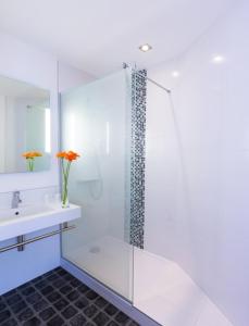 ein weißes Bad mit einer Dusche und einem Waschbecken in der Unterkunft ibis Styles Strasbourg Centre Petite France in Straßburg