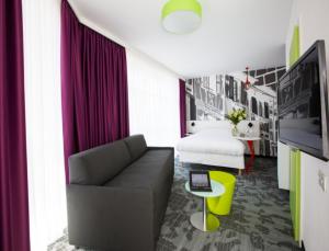 sala de estar con sofá y cama en ibis Styles Strasbourg Centre Petite France, en Estrasburgo