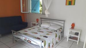una camera da letto con un letto, una sedia e una finestra di ti case gwada location a Sainte-Anne