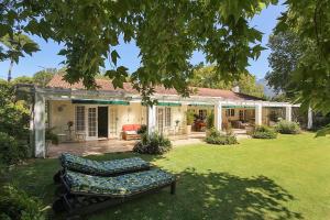 una casa con giardino con panchina in cortile di Beluga of Constantia Guest House a Città del Capo