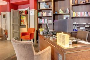 biblioteca con escritorio, ordenador y silla en Crystal Hotel, en París