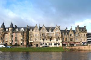 duży budynek obok zbiornika wodnego w obiekcie Columba Hotel Inverness by Compass Hospitality w mieście Inverness