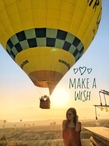 a woman standing in front of a hot air balloon at Wish Cappadocia in Uçhisar