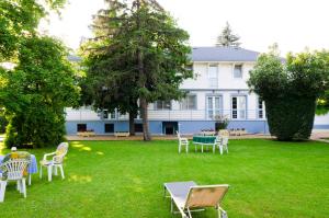 une cour avec des chaises et des tables en face d'une maison dans l'établissement Samson Apartment, à Hajdúszoboszló