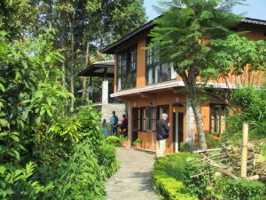 a man standing in front of a house at The Begnas Lake Resort & Villas in Pokhara