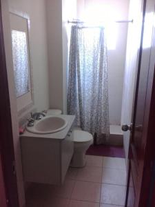 y baño con lavabo, aseo y espejo. en Villa marina, santa elena, en Santa Elena