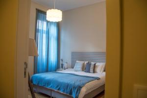 a bedroom with a bed with blue sheets and a window at Sweet Swell in Porto
