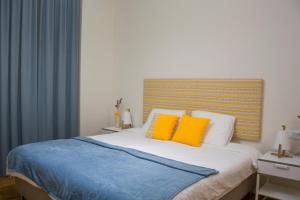 a bedroom with a bed with two yellow pillows at Sweet Swell in Porto