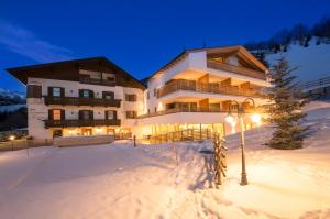 een groot gebouw in de sneeuw 's nachts bij Hotel Restaurant Schaurhof in Vipiteno