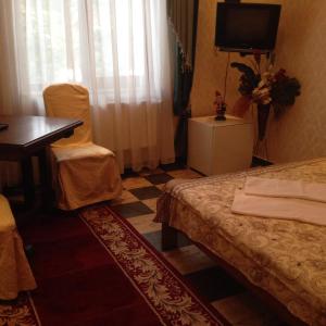 a room with two beds and a desk and a television at Львівське Передмістя in Lviv