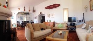 a living room with a couch and a table at Jho'La Surf Camp in Luz