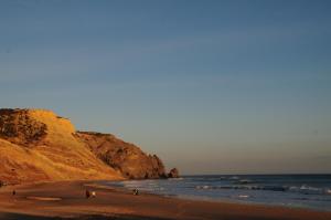 a group of people walking on a beach near the ocean at Jho'La Surf Camp in Luz