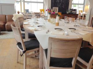mesa de comedor con mantel y sillas blancas en Samsam, en Meerssen