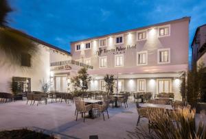 eine Terrasse mit Tischen und Stühlen vor einem Gebäude in der Unterkunft Torretta Palace Hotel in Turanj