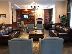 a living room with leather couches and a tv at Chateau Saint John Trademark Collection by Wyndham in Saint John