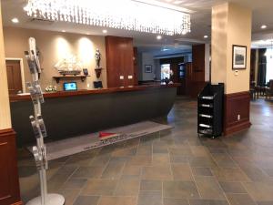 een lobby met een bar in het midden van een salon bij Chateau Saint John Trademark Collection by Wyndham in Saint John