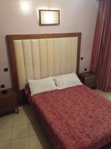 um quarto com uma cama grande e um cobertor vermelho em Hotel Boustane em Casablanca
