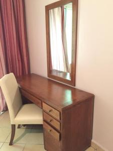 escritorio de madera con espejo y silla en Hotel Boustane en Casablanca