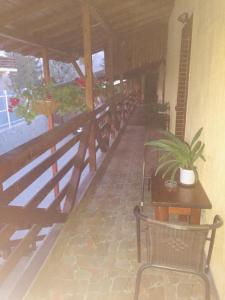 a porch with a bench and a table with a plant at Casa Ade in Slănic