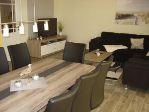 ein Wohnzimmer mit einem Tisch, Stühlen und einem Sofa in der Unterkunft Ferienhaus Seeschwalbe in Fehmarn