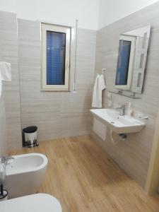 a white bathroom with a sink and a toilet at Hotel 3 Vellezerit in Durrës