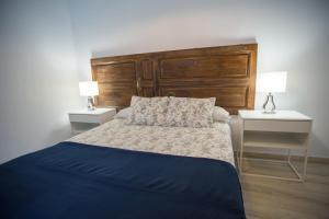 ein Schlafzimmer mit einem großen Bett mit zwei Nachttischen in der Unterkunft Apartamentos Catedral in Málaga
