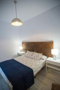 1 dormitorio con 1 cama y 2 mesas con lámparas en Apartamentos Catedral, en Málaga