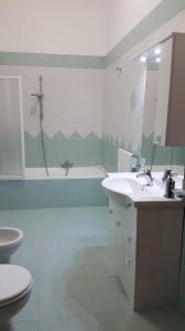 Solarino的住宿－A casa di Pamy，一间带水槽、浴缸和卫生间的浴室