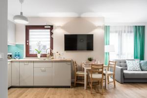 Telewizja i/lub zestaw kina domowego w obiekcie Marinus Apartments SPA - with pool and sauna