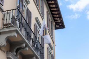 un drapeau sur le côté d'un bâtiment avec balcon dans l'établissement Opera Boutique B&B, à Florence