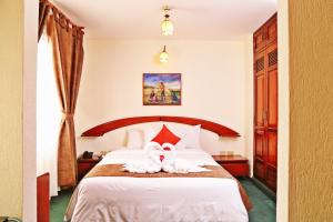 a hotel room with a bed with two towels on it at Apart Hotel Caminos del Inca in Lima