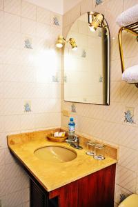 W łazience znajduje się umywalka i lustro. w obiekcie Apart Hotel Caminos del Inca w mieście Lima
