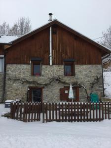 um celeiro com uma cerca em frente dele na neve em Gîte Le Tilleul 1* em Fouillouse