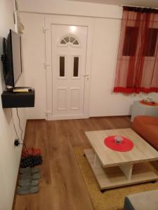 Sala de estar con puerta blanca y mesa en Apartments Popovic en Podgorica