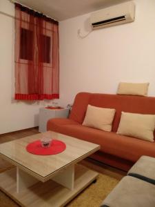 a living room with a red couch and a coffee table at Apartments Popovic in Podgorica