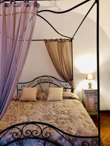 ノーヴィ・リーグレにあるVilla Capanninaのベッドルーム(紫色のカーテン付きの天蓋付きベッド1台付)