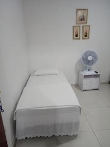a hospital room with a bed and a fan at Cantinho do Canaã in Arraial do Cabo
