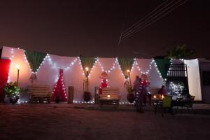 grupa ludzi stojących przed namiotem z lampkami świątecznymi w obiekcie Van Der Salle w Akrze