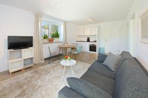 a living room with a couch and a table at Landhotel Herzberger garni Zimmer & Ferienwohnungen in Scheidegg +26 photos